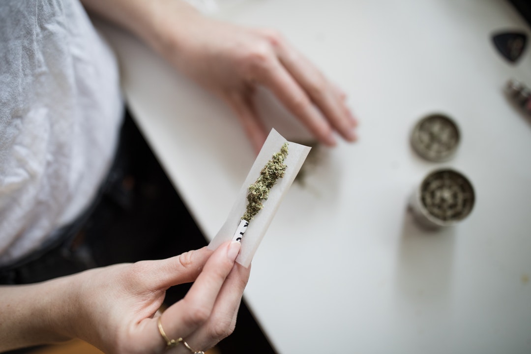 person rolling marijuana joint